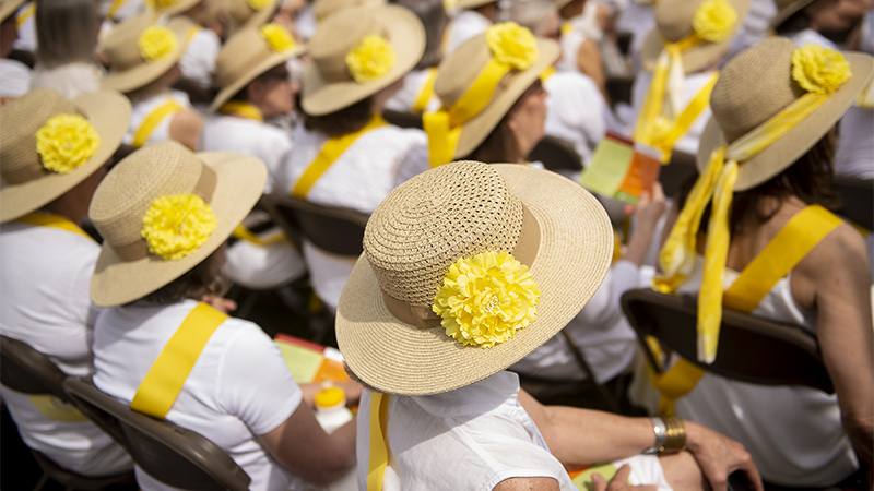 Alumnae wearing matching hats sitting at Ivy Day