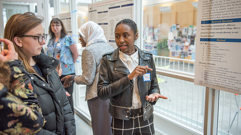 Student discussing her poster in the campus center