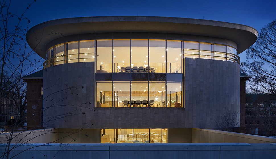 Outside view of the side Neilson library at night, with windows illuminated inside