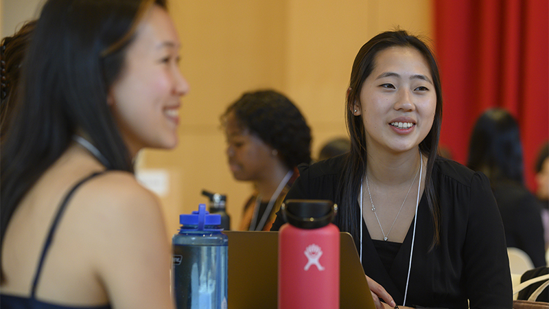 Two students sitting and talking at an event