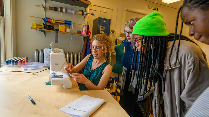 Students learning how to use the sewing machine