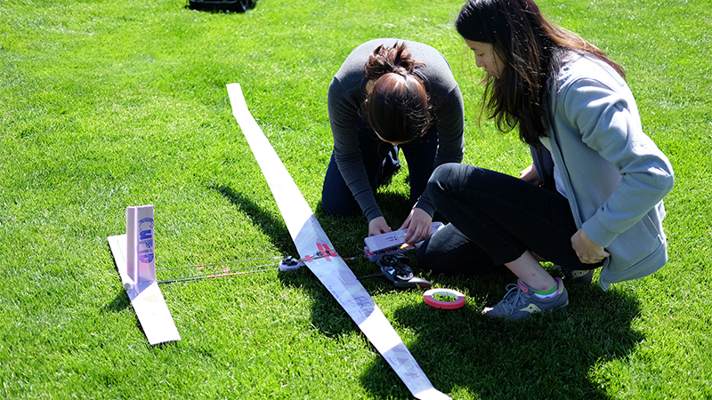 Two students working on building a plane