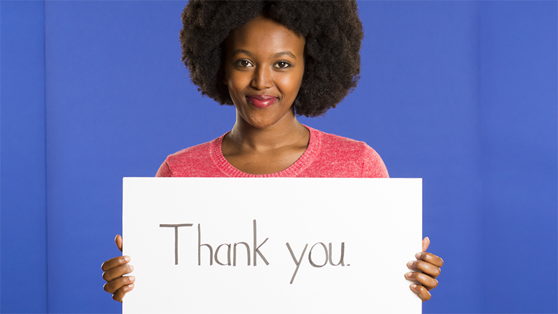 Belise Bwiza holding a sign saying Thank you