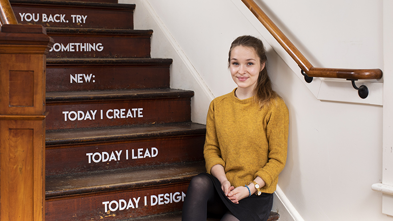 Madeline Turner sitting on the steps in Design Thinking room