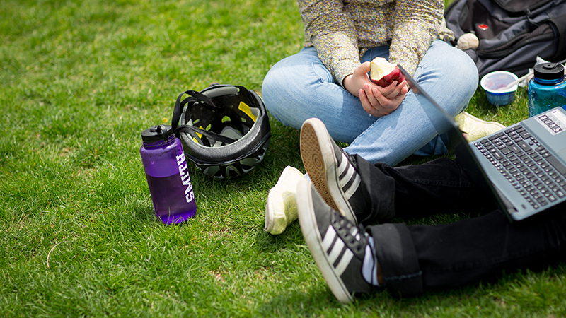 Closeup of the feet of two students on the lawn