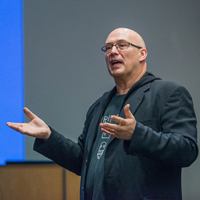 Frazer Ward speaking and demonstrating with his hands in front of a class