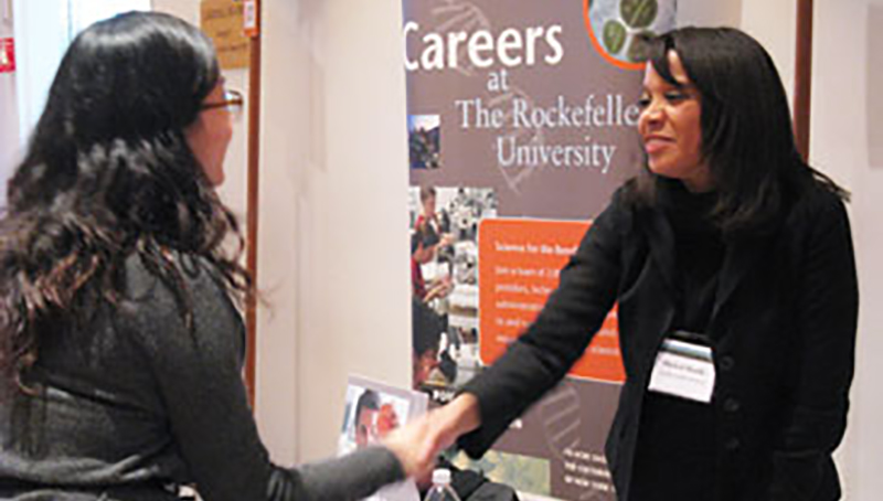 Two women shaking hands at a job fair