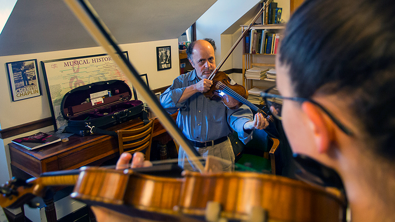 An instructor giving lesson in violin