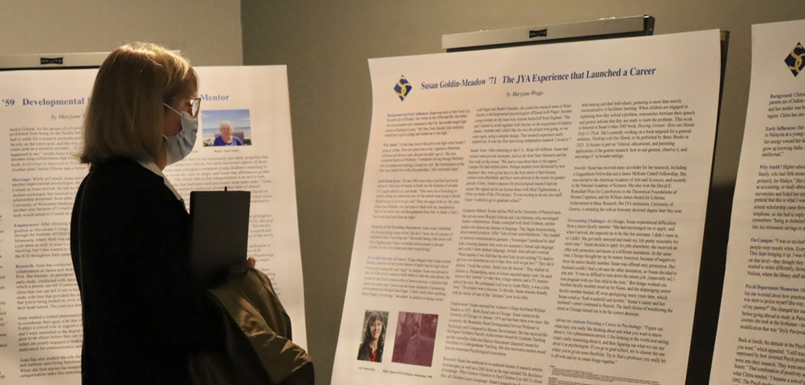 President Kathleen McCartney reads a poster at the psychology centennial symposium.