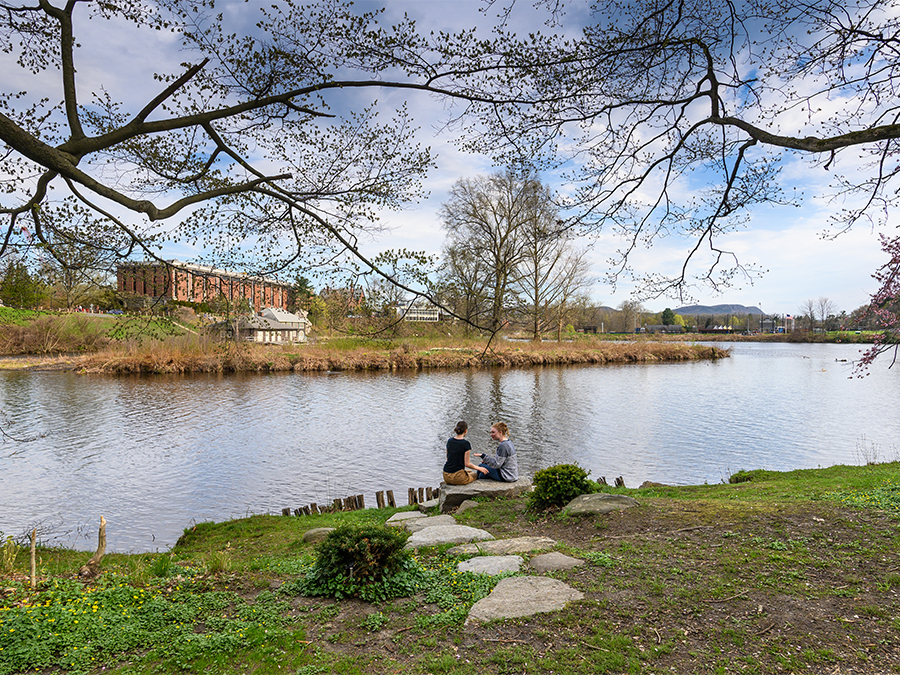 Two students sitting by Paradise Pond