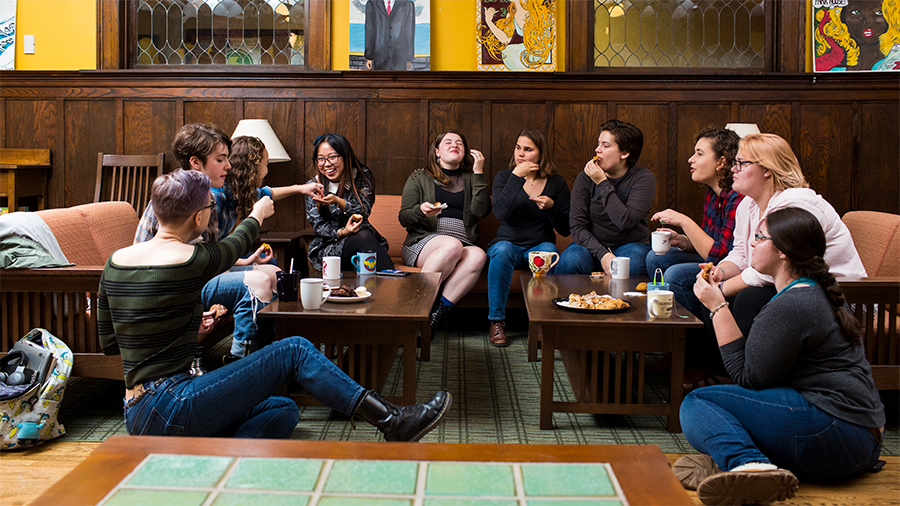 Group of students having tea in a house living room