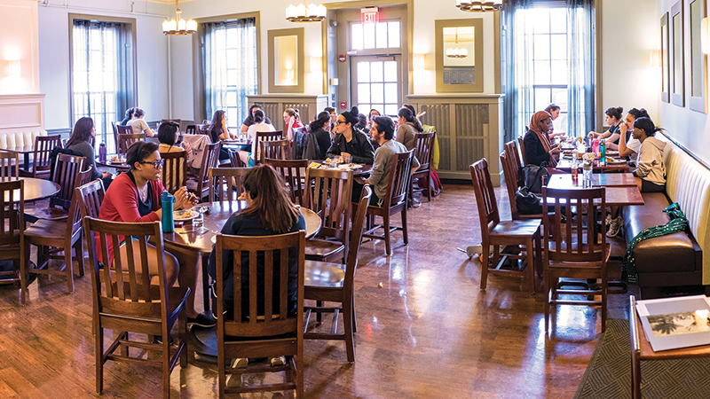 A group of students gathered around a table of snacks