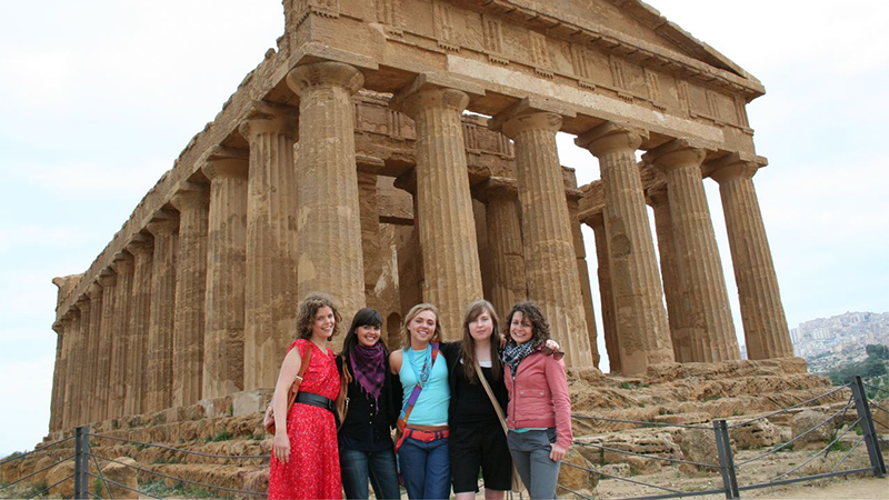 Photo of students posing in front of ancient ruins in Italy