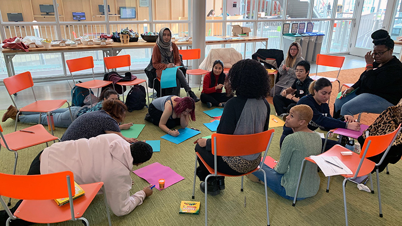 Cohort program group shot of students engaged in a project in the Campus Center