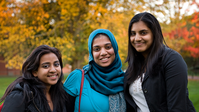 Three students smiling for camera