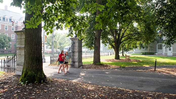 Two students walking through the entry gate to campus