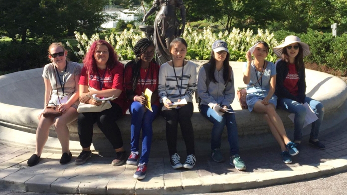 A group of international students sit by fountain, Smith College