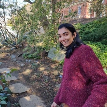 Amrita Acharya smiling along a stone path on campus