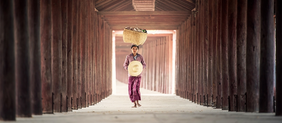 Photo of a woman carrying a basket on her head