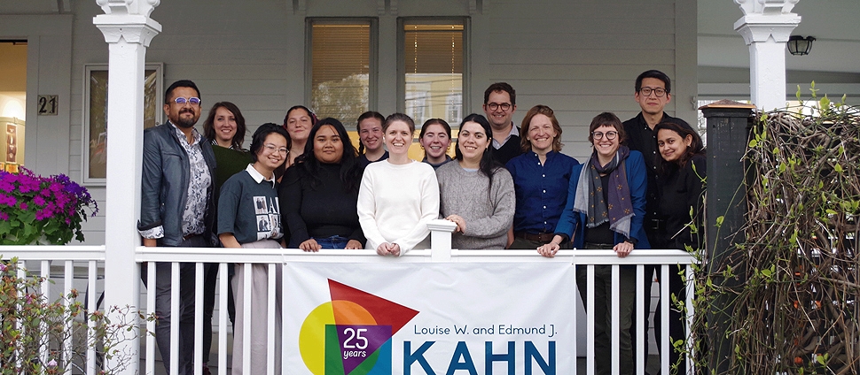 Group of people posing on the porch behind a Kahn Institute banner