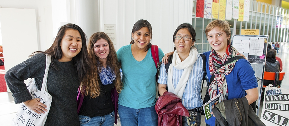 A group of smiling students posing in the Campus Center