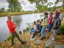 Reid Bertone-Johnson on a river bank teaching students