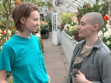 Bridget and Dana looking at each other in a greenhouse