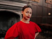 Camille Bacon in a red dress with red lipstick