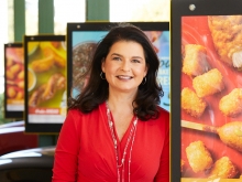 Claudia San Pedro smiling by the menus at a Sonic restaurant