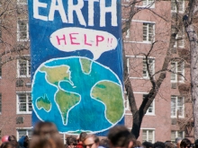 Earth Day 1970. A large banner with the globe saying "help" and EARTH in large letters. Below it is a large crowd.