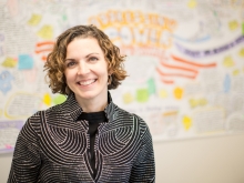 Erin Cohn against a out-of-focus white board covered with writing in bright marker