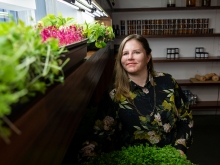 Jessie Banhazl next to hydroponic vegetables