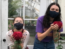 Mai Klooster and Sasha Zeidenberg holding large mum flowers