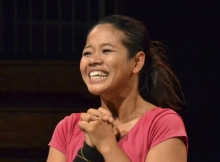 Phounam Pin smiling broadly on a stage