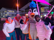 Valerie Love standing with the FIFA mascot and two other volunteers
