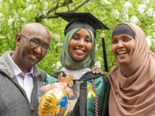 student in a hijab with her family at commencement