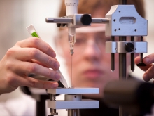 Closeup of a student's hands adjusting a scientific instrument