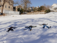 Three students creating snow angels