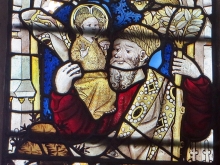 Crop of medieval stained glass showing a figure with a syphilitic nose