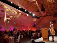 Student at a podium speaks to a dinner gathering