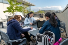 A group of four students study at a table on the Neilson Library rooftop