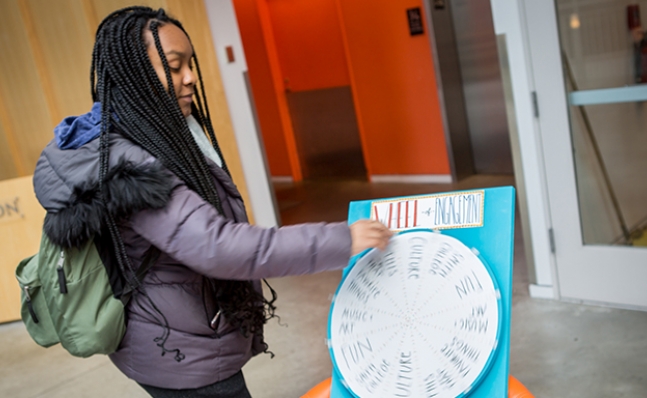 Student spinning the "Wheel of Engagement" at the Campus Center