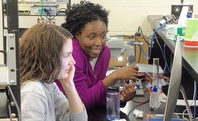 Two students at computer in lab