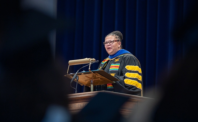 Sarah Willie-LeBreton in academic regalia speaking at the School for Social Work commencement.