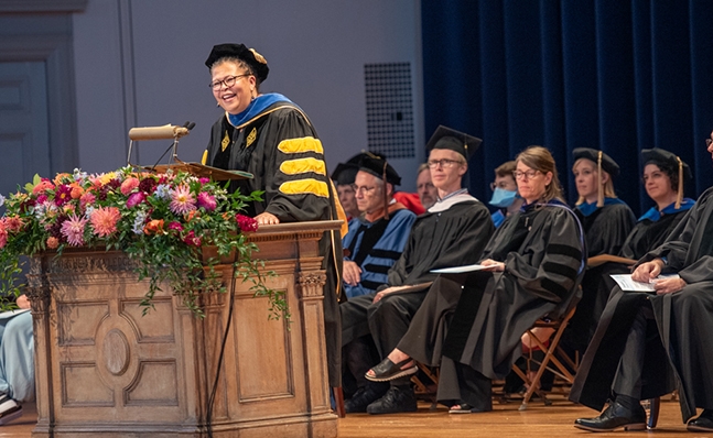 President Sarah Willie-LeBreton in academic regalia, speaking at the President's Welcome Assembly.