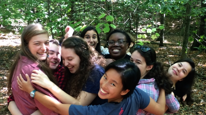 Group of eight students in a circle hugging